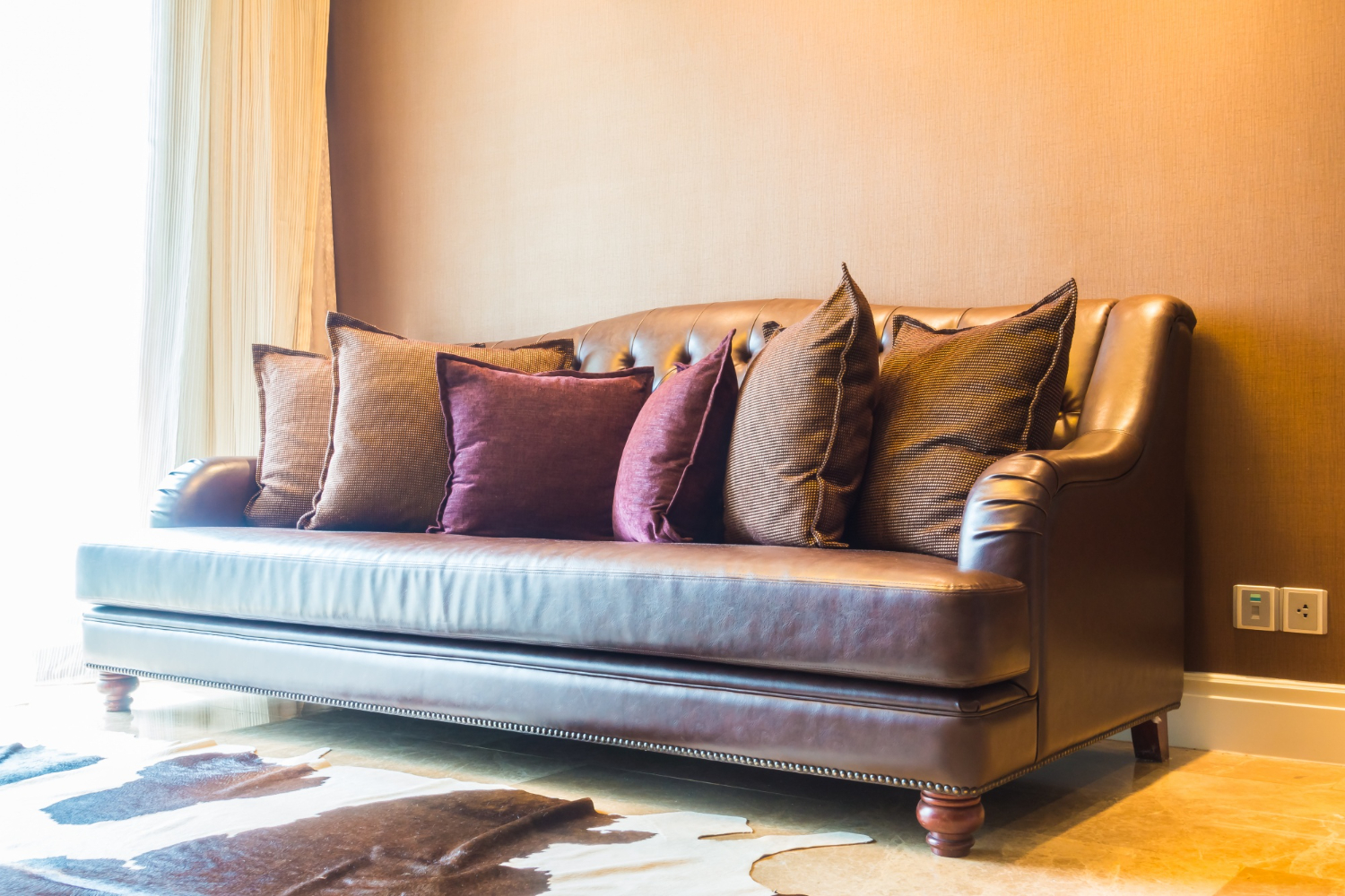 Classic leather sofa styled with warm cushions